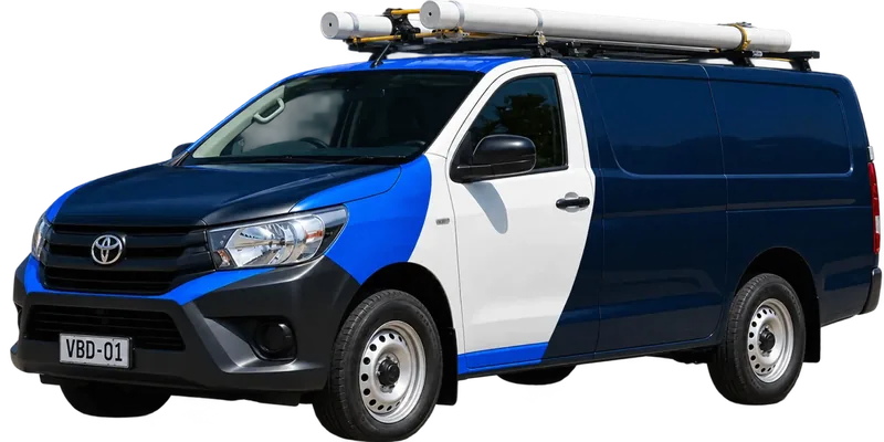 A licensed Caringbah plumbing van loaded with pipe on the roof rack
